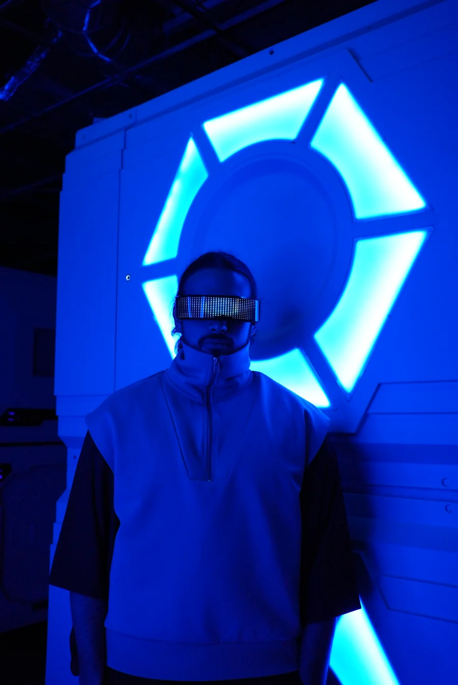 Marcus Milosevic, VERAXON, wearing an illuminated visor in a blue-lit space.